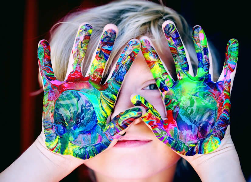 Niño con manos pintadas